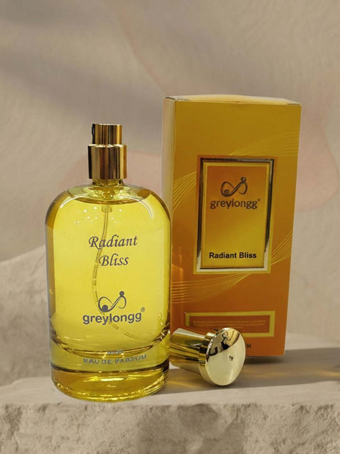 Greylongg Radiant Bliss eau de parfum bottle and gold box on a stone ledge