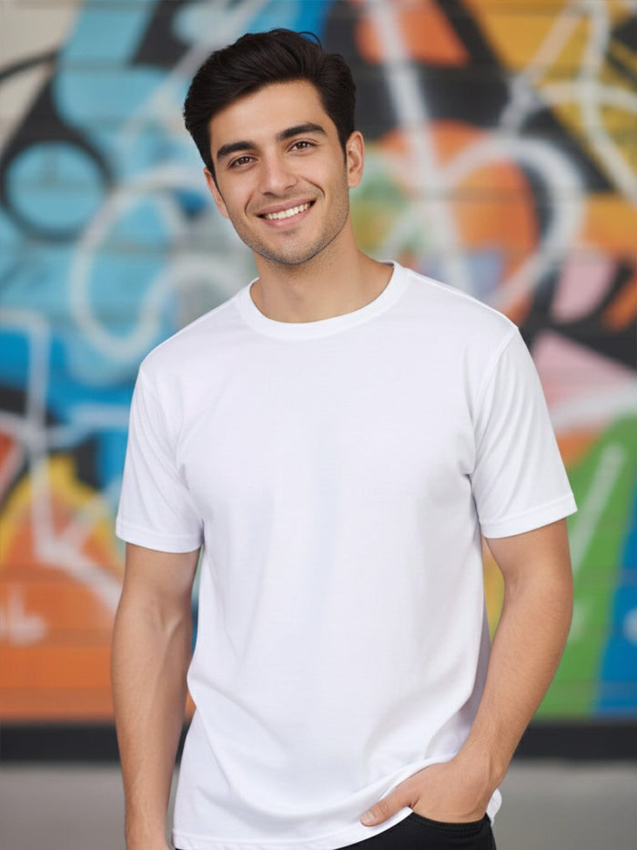 Man in a plain white round neck T-shirt in front of a colourful graffiti wall