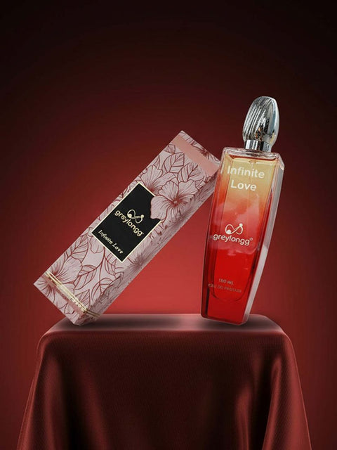 Greylongg Infinite Love eau de parfum bottle and floral box on a red cloth